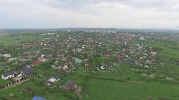 Kleinstadt mit niedrigen Häusern in frühlingshafter Natur. Luftbild — Stockvideo