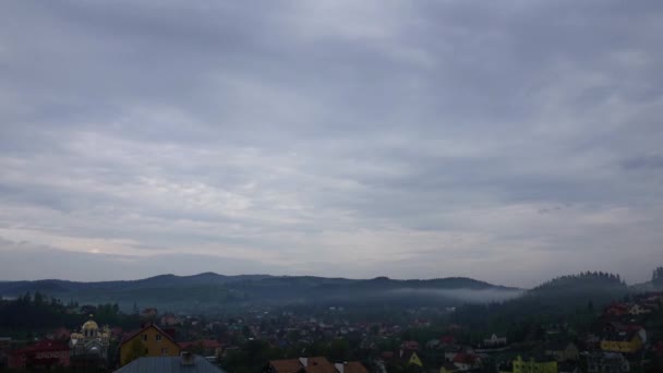 Lluviosas nubes de primavera grises sobre la pequeña ciudad en las montañas, timelapse — Vídeo de stock