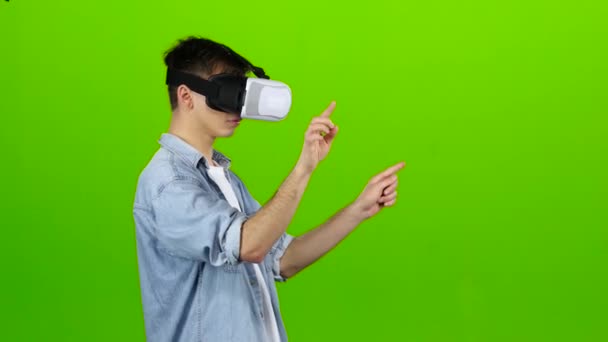 Людина в окулярах віртуальної реальності будує графіку. Зелений екран — стокове відео