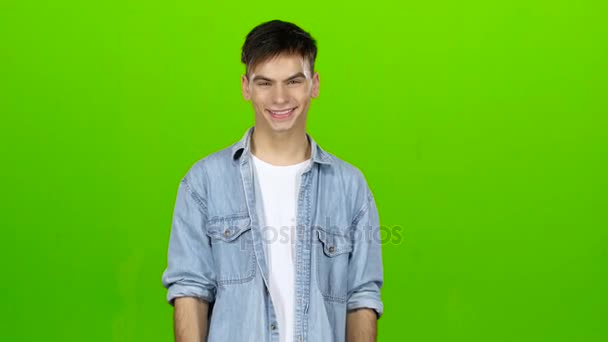 Guy cute smiles and shows two thrumbs up. Green screen — Stock Video