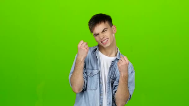 Young guy is happy with his victories, he is happy. Green screen — Stock Video