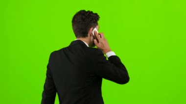 Adam işe gider ve telefonda konuşuyor. Yeşil ekran. Arkadan Görünüm