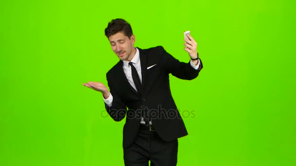 El hombre de negocios camina, pulsa un cuaderno, y hace una selfie. Pantalla verde. Vista lateral — Vídeos de Stock