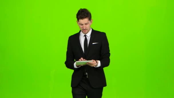 El hombre de negocios camina, pulsa un cuaderno, y hace una selfie. Pantalla verde — Vídeos de Stock