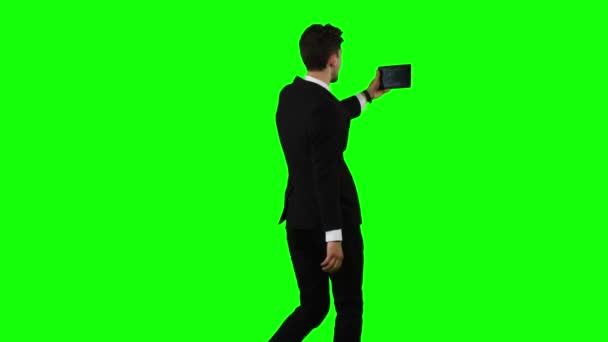 Der Geschäftsmann geht, hält ein Notizbuch in der Hand und macht ein Selfie. Green Screen — Stockvideo