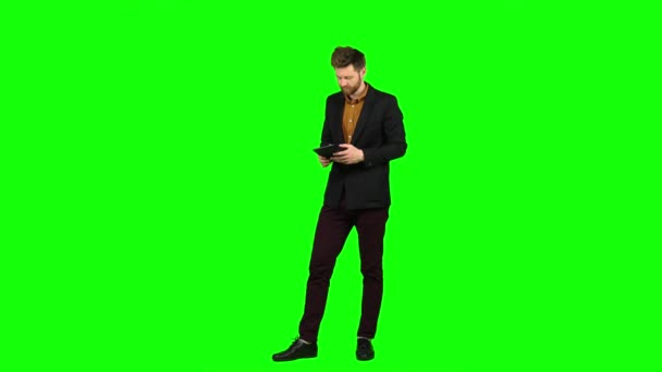 Man considers money on a calculator and is happy that he has income. Green screen — Stock Video