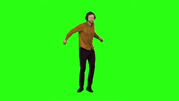 Ο τύπος στα ακουστικά χορούς και περιστρέφει γύρω από και διασκεδάζοντας. Πράσινη οθόνη — Αρχείο Βίντεο