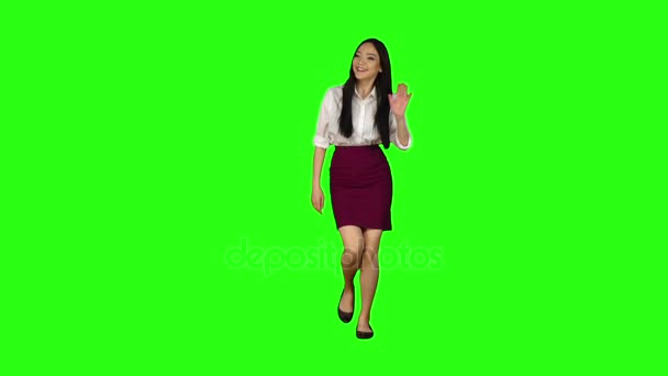 Girl of asian appearance goes to work and waves her hand. Green screen. Slow motion — Stock Video