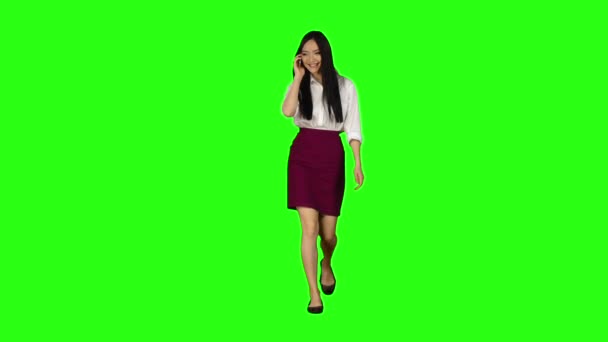소녀는 거리를 걷는다, 전화 재미 있는 사진에서 보인다. 녹색 화면입니다. 슬로우 모션 — 비디오
