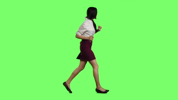 Девушка азиатской внешности с телефоном бежит на важную встречу. Зеленый экран. Медленное движение — стоковое видео
