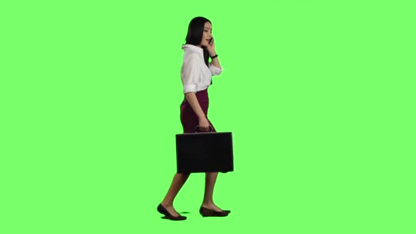 Ázsiai lány úgy néz ki a telefon, és fut. Zöld képernyő. Lassú mozgás — Stock videók