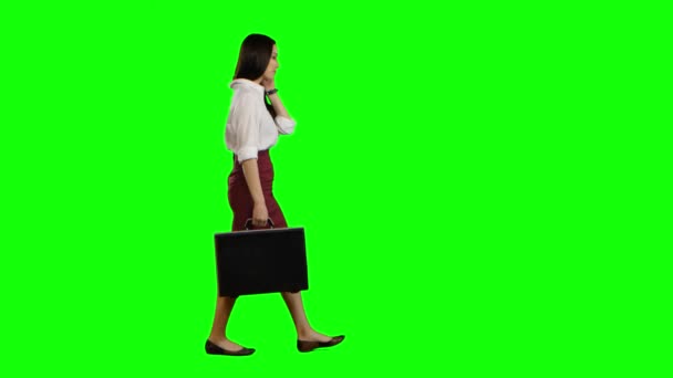Chica asiática mira por teléfono y corre. Pantalla verde — Vídeos de Stock