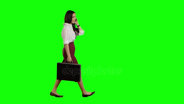 Meisje spreekt op de telefoon, in de hand houdt een diplomaat. Groen scherm — Stockvideo