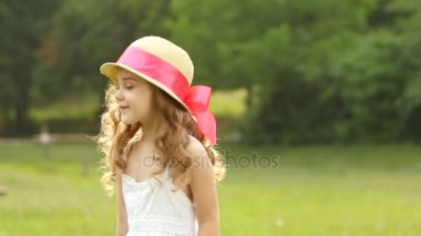 Küçük kız parkta yürüyor ve bir daire içinde dönüyor. Ağır çekim