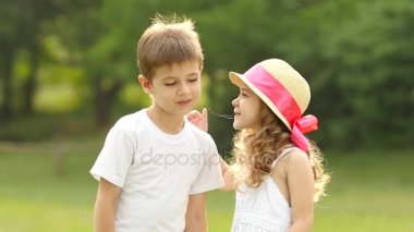 Küçük kız çocuk yanağından öper, o utanıyor ve gülümsüyor. Ağır çekim