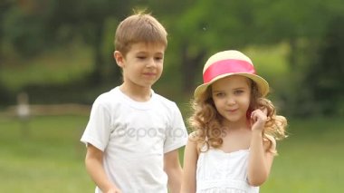 Küçük çocuk, kendi elleriyle gözlerini kıza kapatır. Ağır çekim