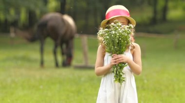 Ellerinde kır çiçekleri ile çocuğu onları burnunu çekmek. Ağır çekim