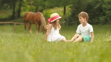 Çocuklar parkta Çimenlikte oturan, bunlar konuşmak güzeldi ve eğleniyor. Ağır çekim