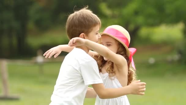 Petit garçon étreint doucement la fille, ils sont heureux et insouciants. Mouvement lent — Video