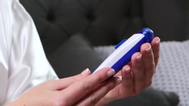 Vrouw met een handen gratis epilator onderzoekt hoe het werkt. Close-up — Stockvideo
