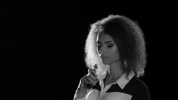 Chica afroamericana fuma un cigarrillo electrónico en una habitación vacía. Blanco y negro — Vídeos de Stock