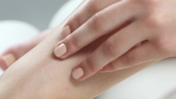 Κορίτσι δαπανά το χέρι της πάνω από το λείο δέρμα στο πόδι της. Κοντινό πλάνο — Αρχείο Βίντεο