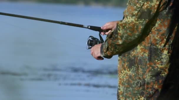 Fiskaren innehar ett fiskespö i handen och fångar fisk för bete — Stockvideo