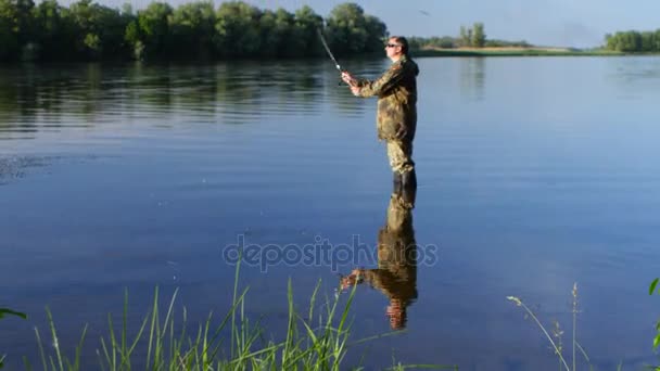 Pescador disfruta de la recreación al aire libre, la pesca para girar y disfrutar de su captura — Vídeo de stock