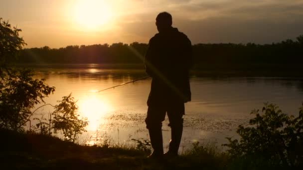 Man besteedt zijn vrije tijd in de natuur en vissen bij zonsondergang — Stockvideo