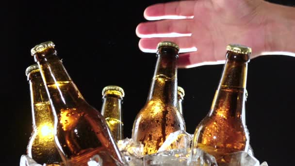 El bir şişe soğuk bira alır. Siyah arka plan. Yakın çekim — Stok video