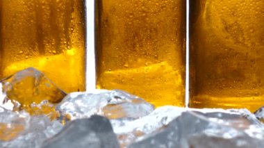 Buz yalan arkasındaki masada bira şişesi vardır. Beyaz arka plan. Yakın çekim