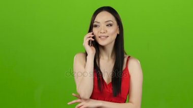 Asyalı kız telefonda, onu kız arkadaşıyla dedikodu görünüyor. Yeşil ekran