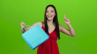 Kız bir hediye aldı, bu açılır ve sevinir. Yeşil ekran. Ağır çekim