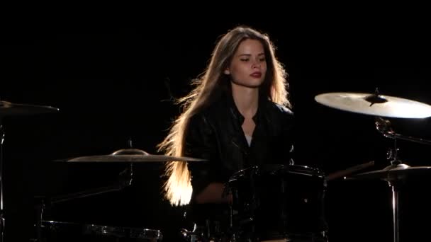 Schlagzeugermädchen beginnt energiegeladene Musik zu spielen, sie lächelt. schwarzer Hintergrund — Stockvideo