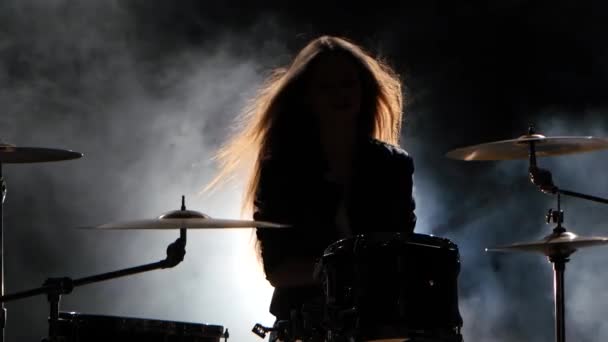 Спеціально підготовлені дівчина грає на барабанах. Чорний дим фону. Силует — стокове відео