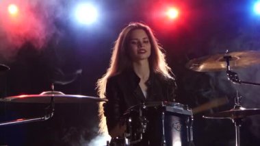 Davulcu profesyonel bir müzik aleti çalıyor. Siyah duman arka plan. Arkadan kırmızı mavi ışık