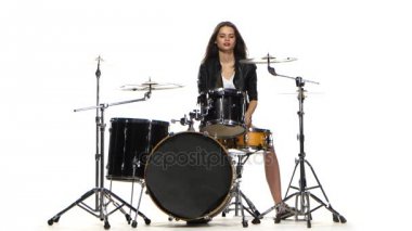 Baterist kız enerjik müzik, o gülümsüyor çalmaya başlar. Beyaz arka plan