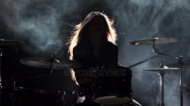 Enerjik müzik davul, oynamaya başladı kızdır. Siyah duman arka plan. Siluet. Ağır çekim