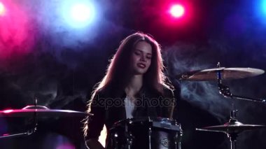 Davulcu profesyonel bir müzik aleti çalıyor. Siyah duman arka plan. Arkadan kırmızı mavi ışık. Ağır çekim