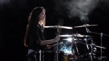 Kız krep yerken üzerine pound için seviyor davul çalıyor. Siyah duman arka plan. Yan görünümü. Ağır çekim