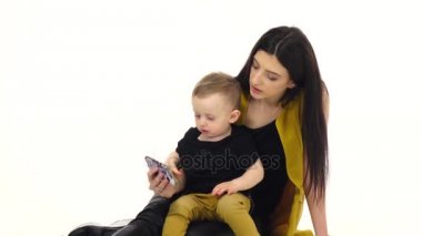 Kız söyler ve bir şey çocuğunu smartphone üzerinde gösterir. Beyaz arka plan