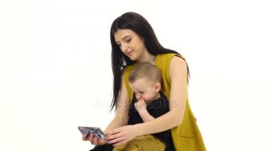 Anne oğlu onun kucağına tutar ve onu eğitir. Beyaz arka plan