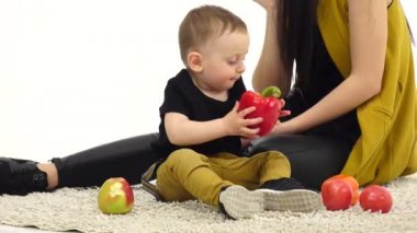 Kız telefonda konuşuyor, çocuğunu bir elma yiyor. Beyaz arka plan