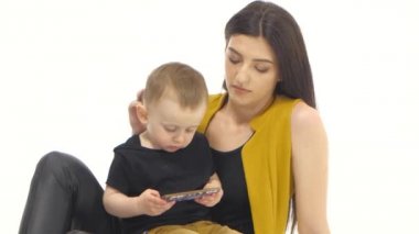 Anne oğlu onun kucağına tutar ve onu eğitir. Beyaz arka plan