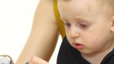 Kız söyler ve bir şey çocuğunu smartphone üzerinde gösterir. Beyaz arka plan. Yakın çekim