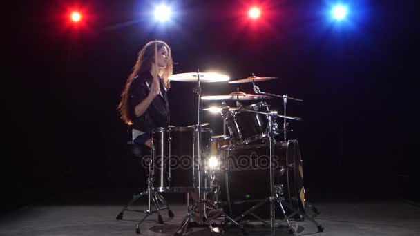 Meisje drummer met stokjes verslaat ritmische muziek. Zwarte achtergrond. Rood licht blauw. Zijaanzicht — Stockvideo