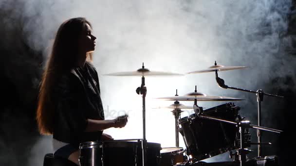 Speciaal opgeleide meisje speelt de drums. Zwarte rook achtergrond. Silhouet — Stockvideo