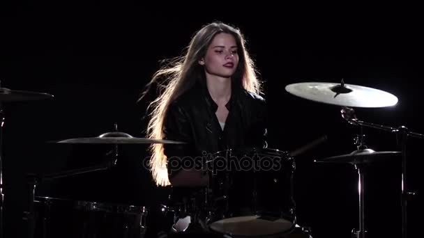 Drummer meisje begint te spelen energieke muziek, ze glimlacht. Zwarte achtergrond. Slow motion — Stockvideo