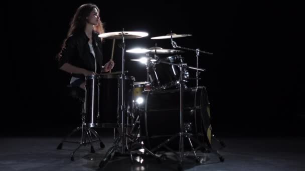 Drummer meisje begint te spelen energieke muziek, ze glimlacht. Zwarte achtergrond. Slow motion — Stockvideo
