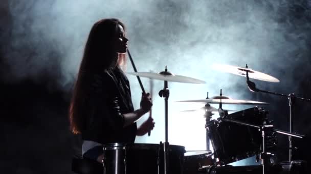 Speciaal opgeleide meisje speelt de drums. Zwarte rook achtergrond. Silhouet. Slow motion — Stockvideo